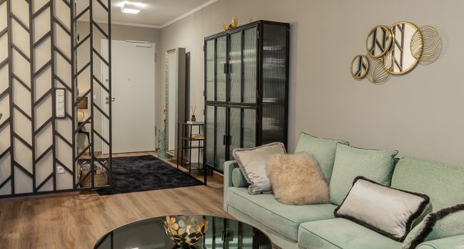 Wohnbereich mit Raumtrenner und modernem Vitrinenschrank.