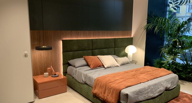 Modern eingerichtetes Schlafzimmer mit grünem Bett und orangen Akzenten.