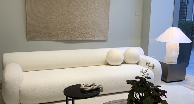 Minimalistisches Wohnzimmer mit weißem Sofa und rundem Couchtisch.