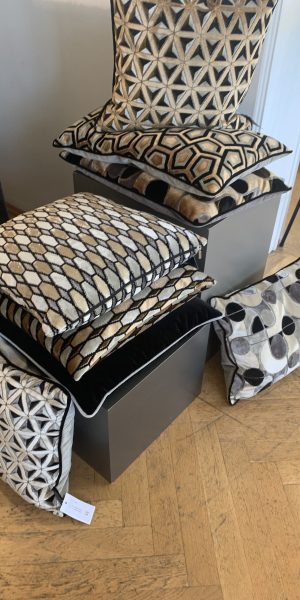 Stapel gemusterter Kissen in verschiedenen Farben und Designs.
